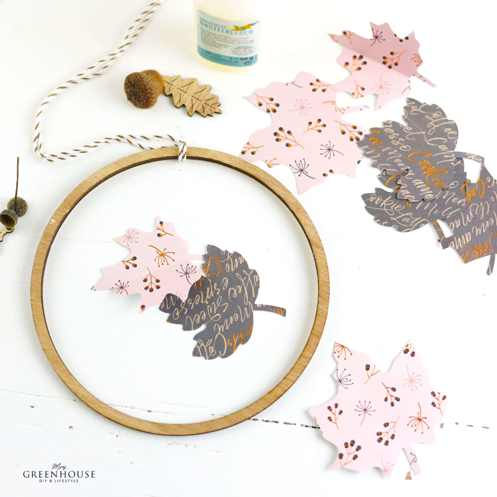 Blätter aus Papier auf Holzkranz kleben