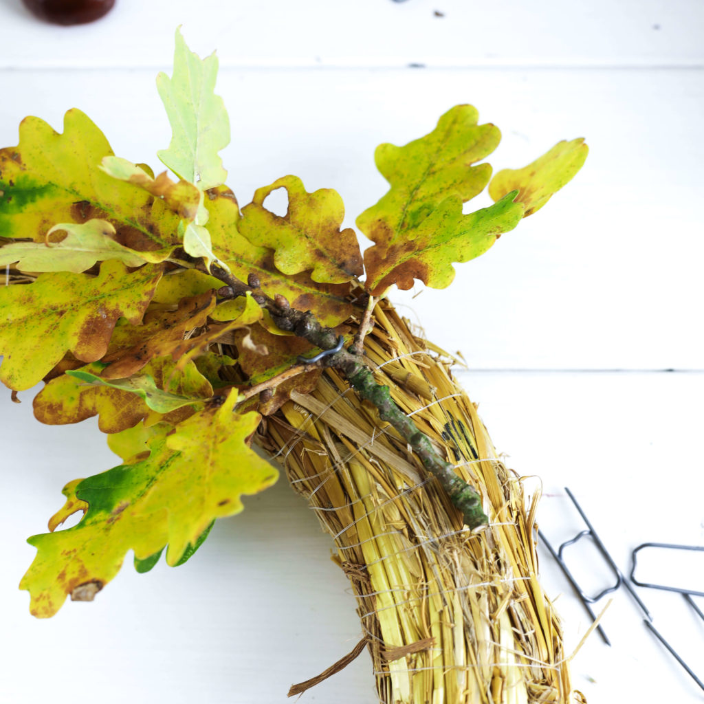 Blätter mit Floristenhaften an den Strohrömer stecken