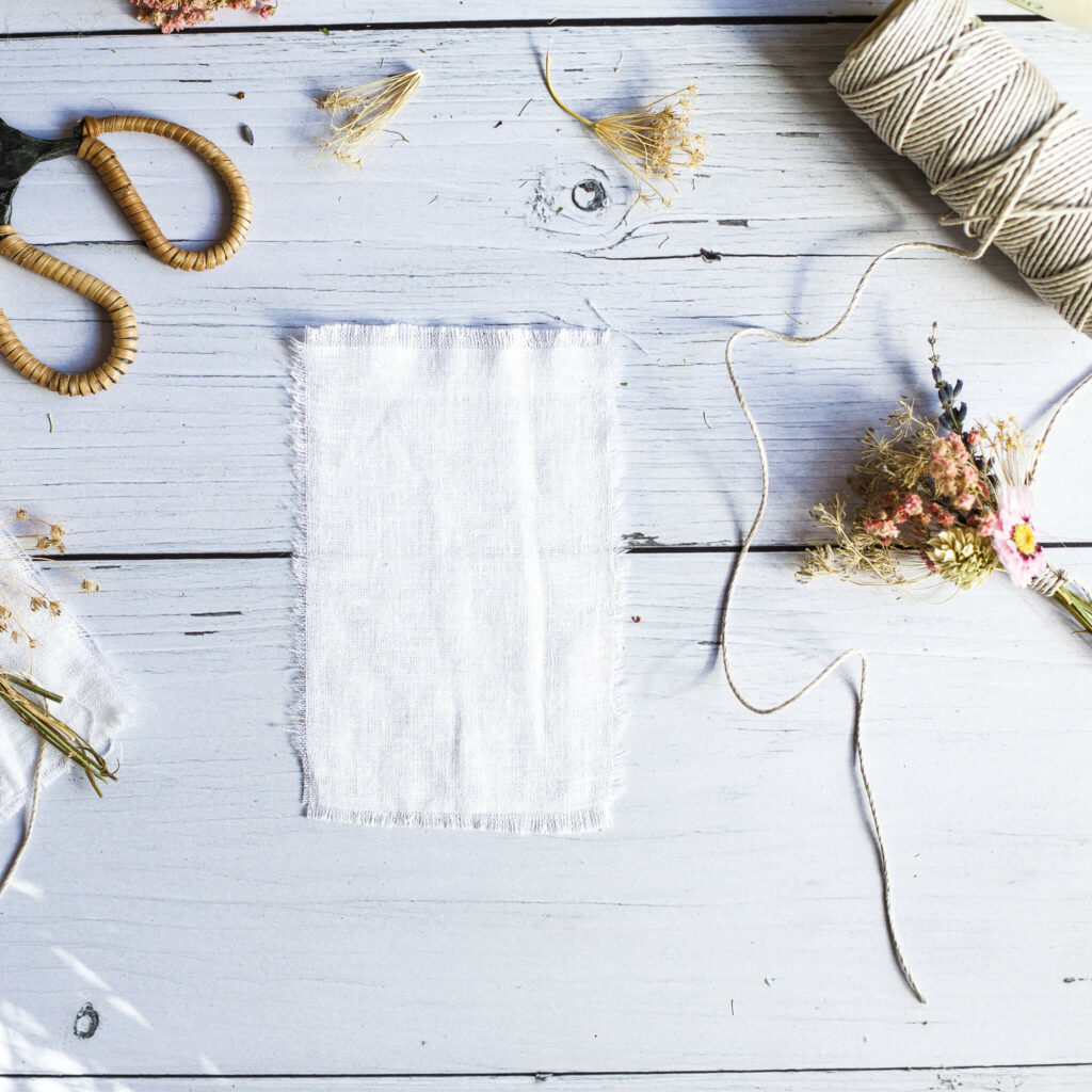 Stoff für Karte mit Trockenblumen zurecht schneiden