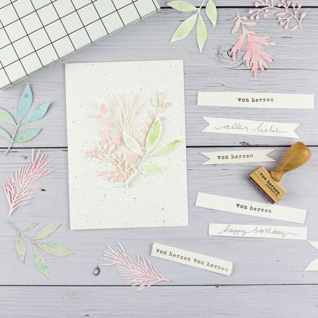 bestempeltes Schild auf Grusskarte kleben