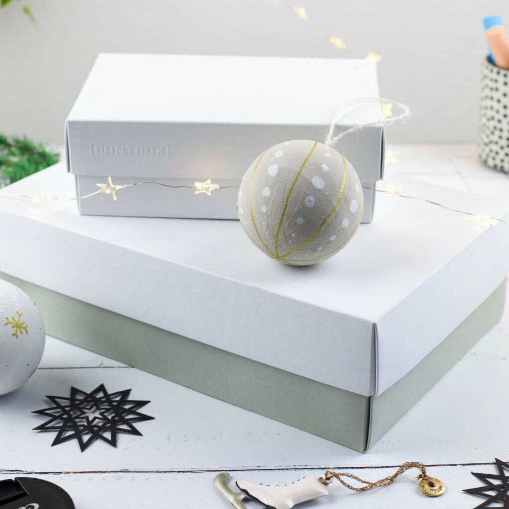 Weihnachtskugeln aus pappmachee verpacken