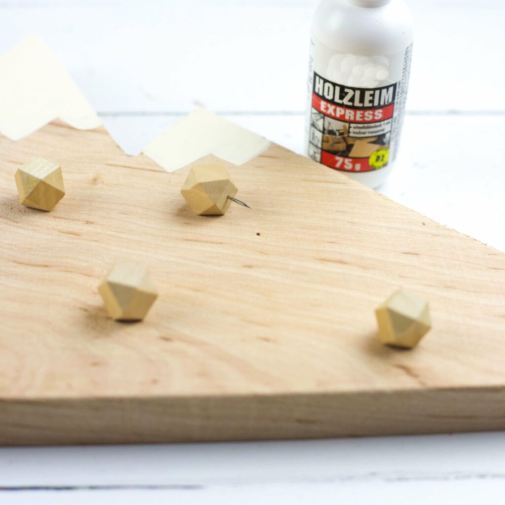 Pinnstecker mit Leim am Adventskalender befestigen