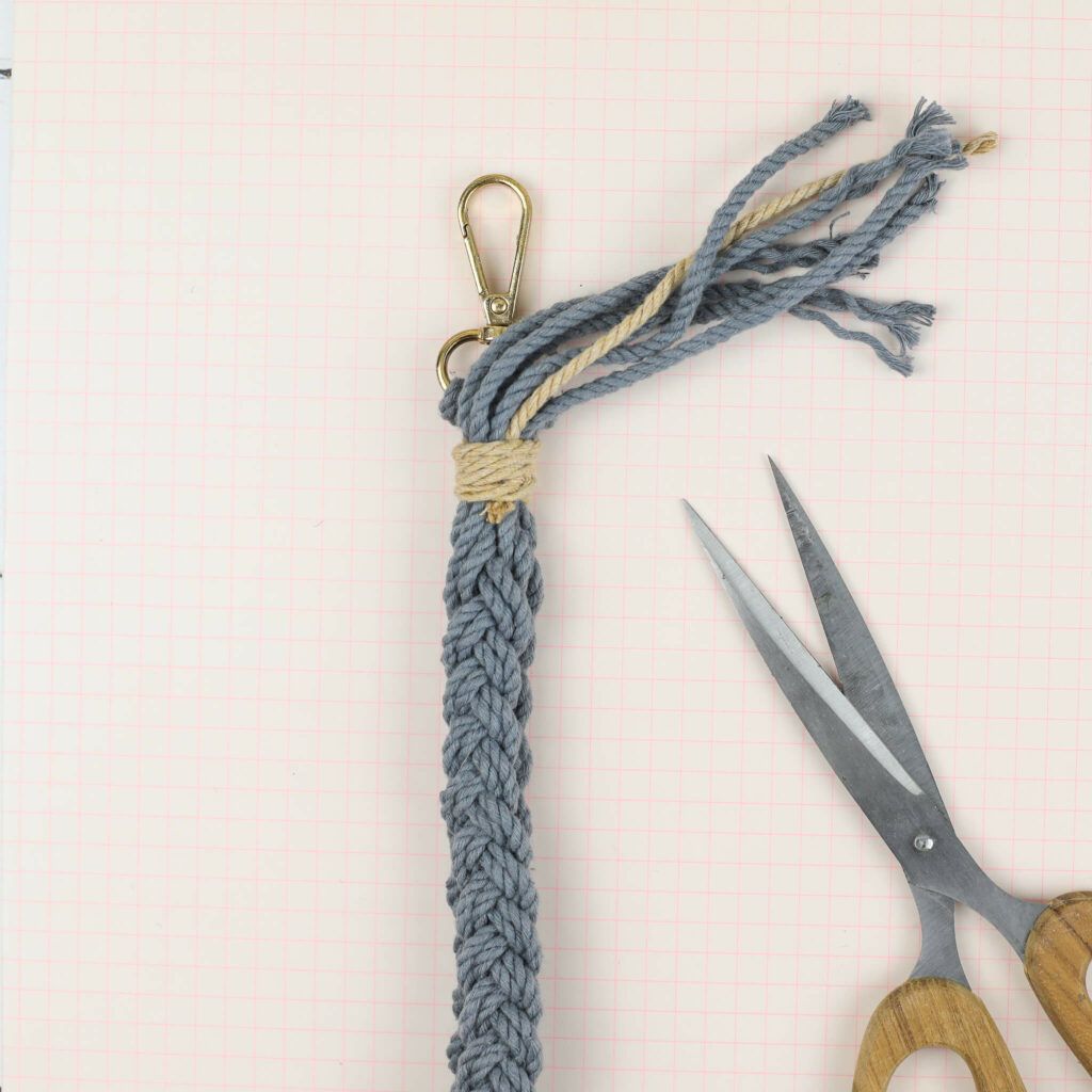 Fäden am geflochtenen Schlüsselanhänger abschneiden