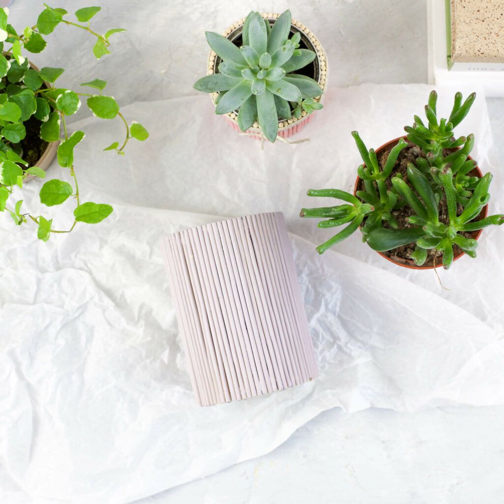 Pflanztöpfe aus Dosen mit Rundhölzern beklebt und mit Sprühlack besprüht