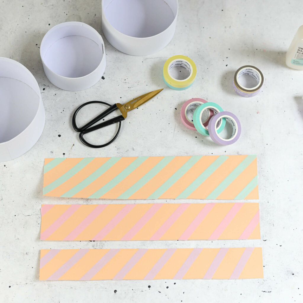 Papierstreifen auf Pappschachteln kleben