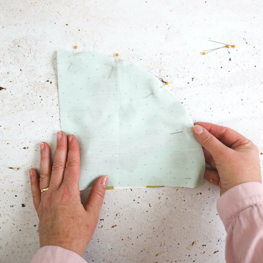 Stoffteile übereinanderlegen und mit Nadeln fixieren.