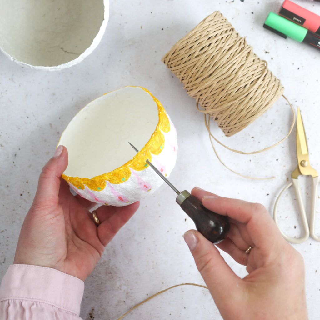 Loch mit einer Ahle auch die Pappmaché Schale bohren