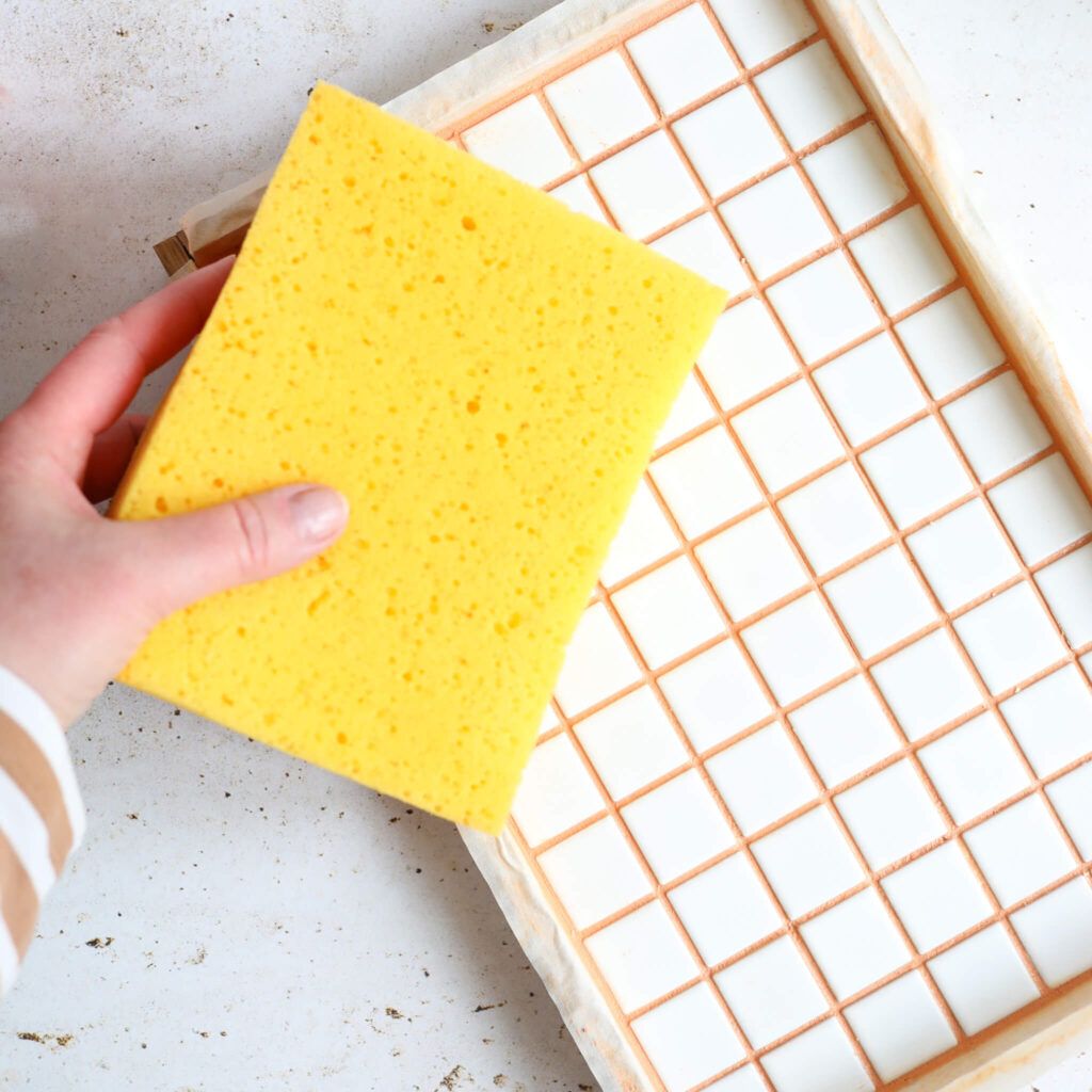 Fugenmasse mit einem Schwamm abnehmen.