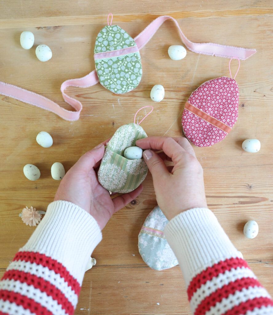 Ostereier aus Stoff mit Süßigkeiten befallen